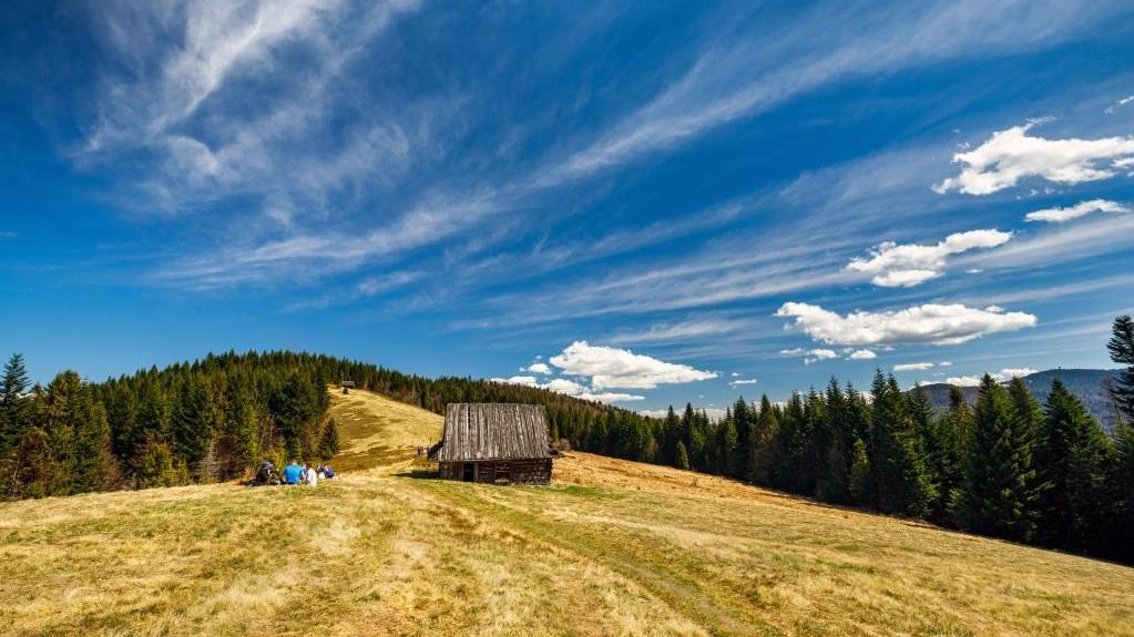 Rozległa polana z dawnymi pasterskimi szałasami w górach